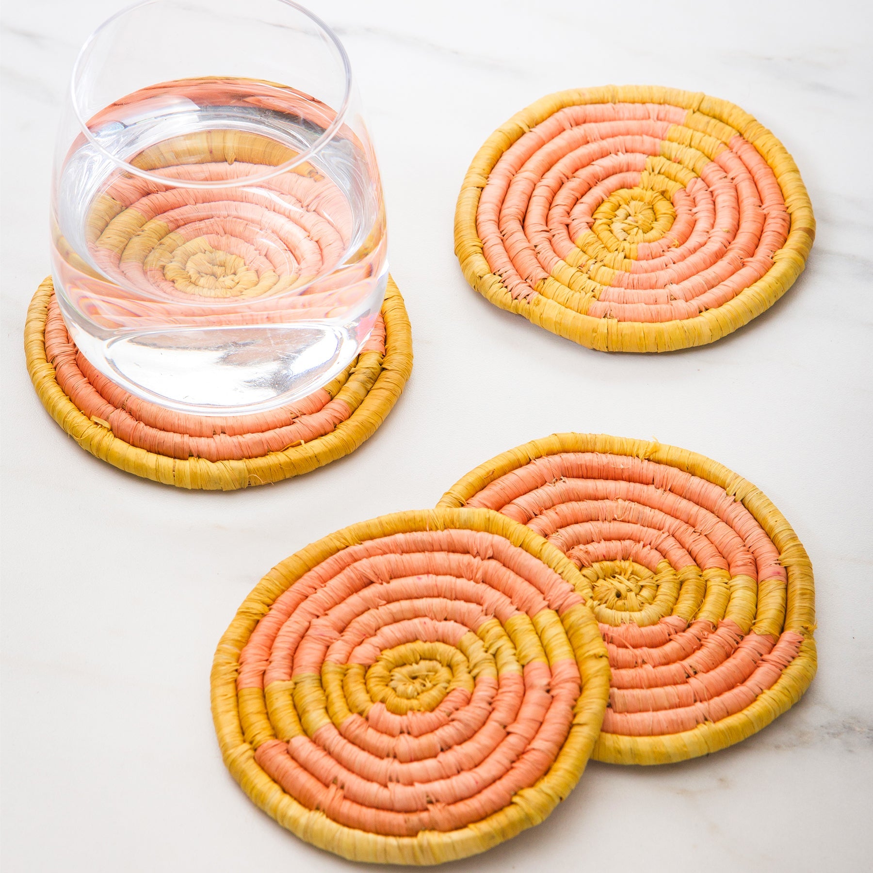  Peach & Mustard Raffia Coasters, Set of 4 by Kazi Goods - Wholesale Kazi Goods - Wholesale Perfumarie