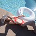 Woman lying on the edge of pool with the brunette swim ring from the best pool float brand