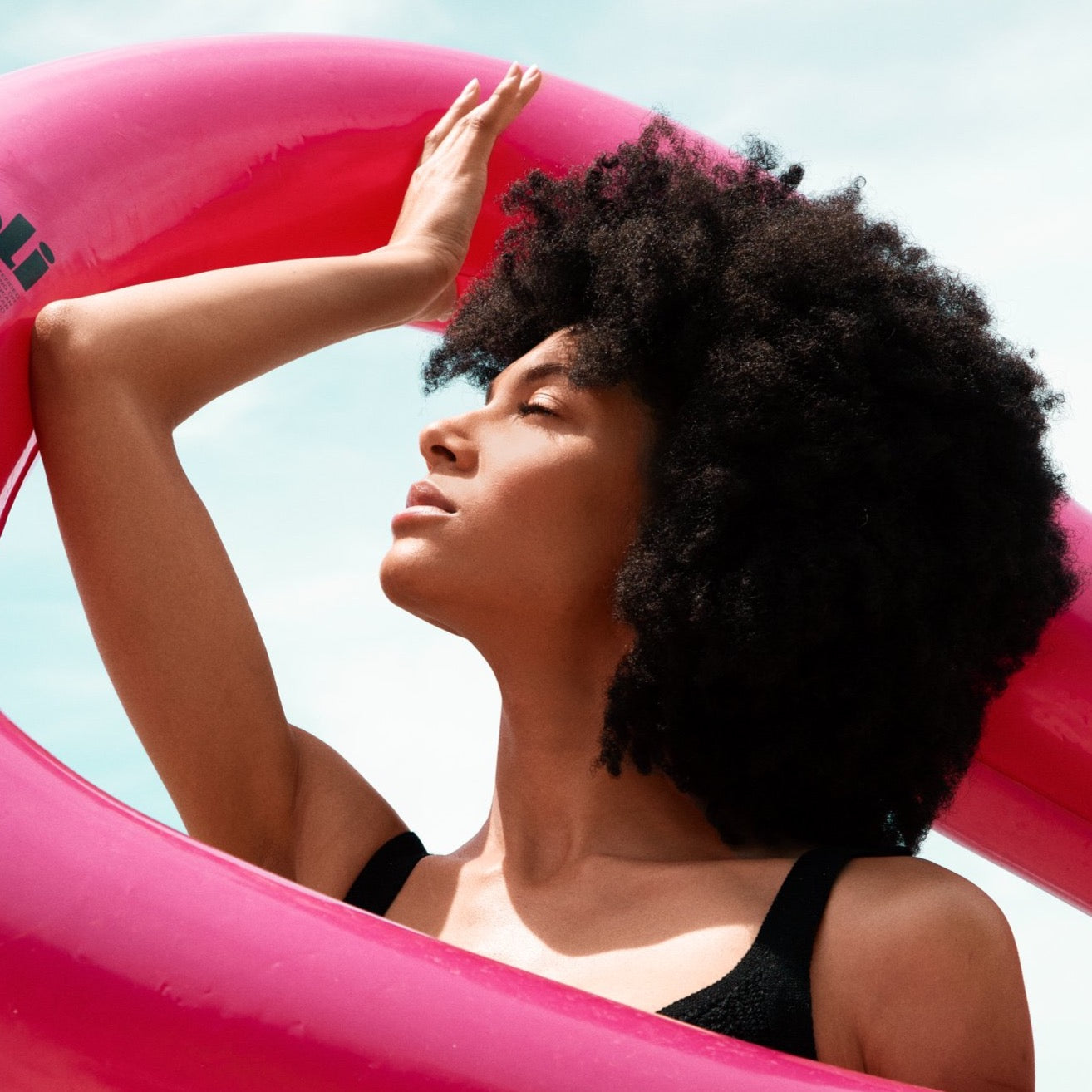Girl holding pink metallic heart shaped pool float