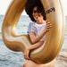 Girl holding gold pool float on the beach